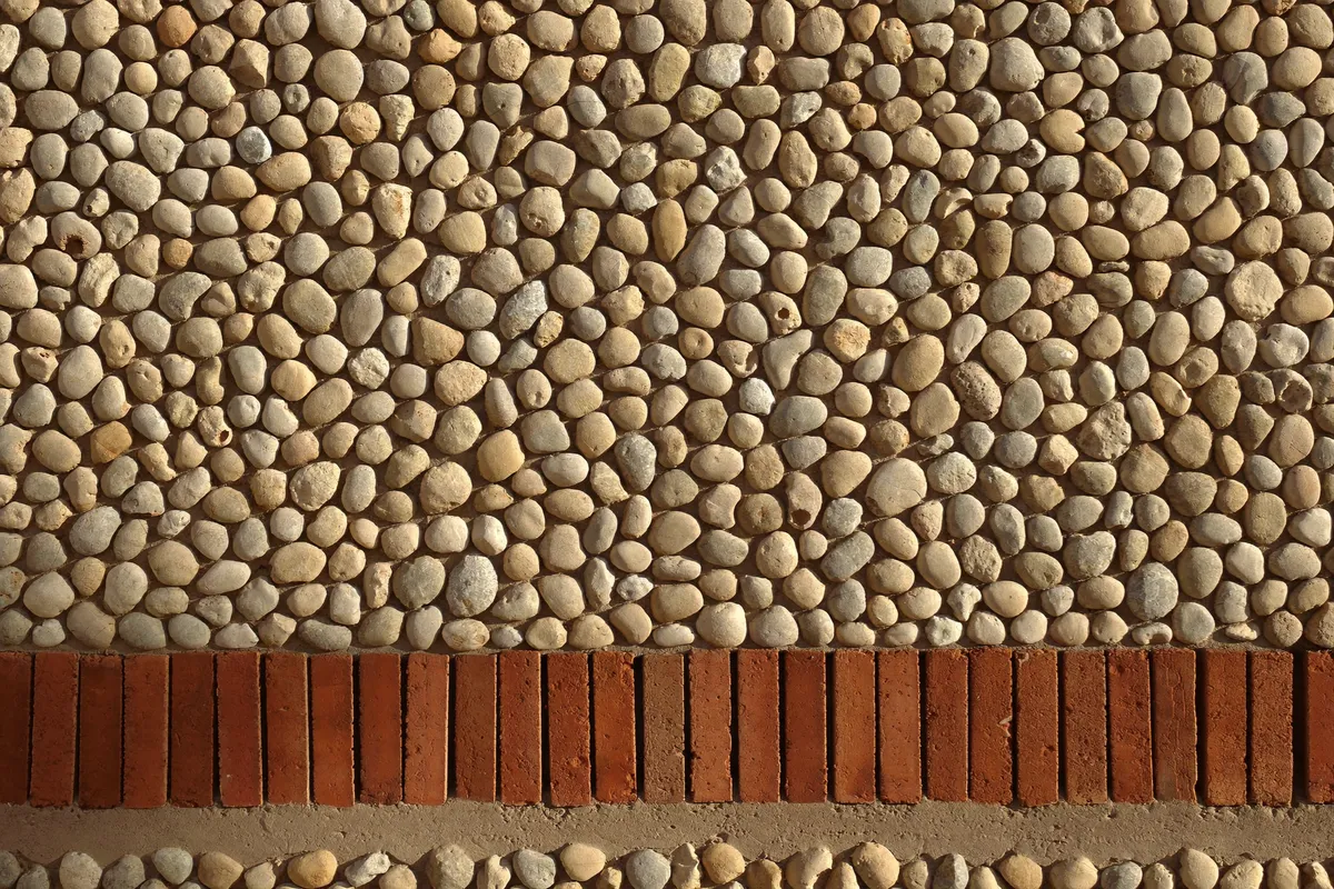 Mur catalan en galets roulés et assises de briques à Perpignan